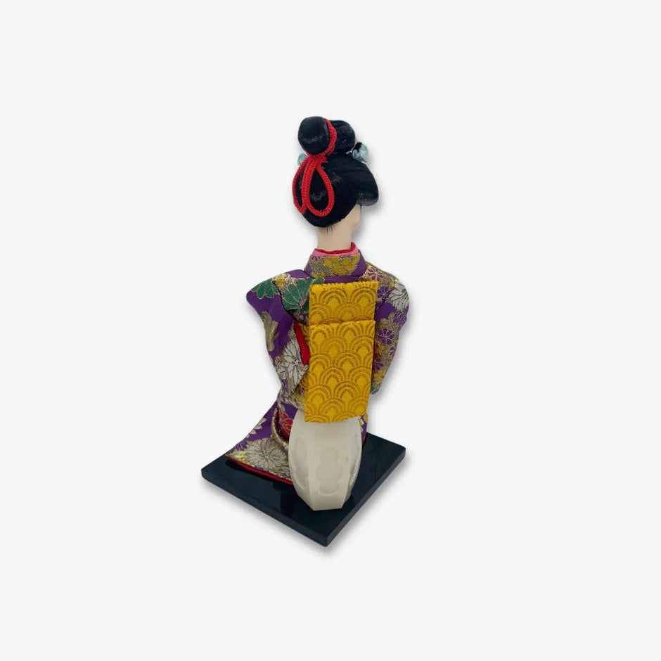 Figura de geisha japonesa con hermoso kimono morado