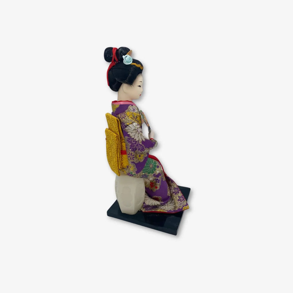 Figura de geisha japonesa con hermoso kimono morado